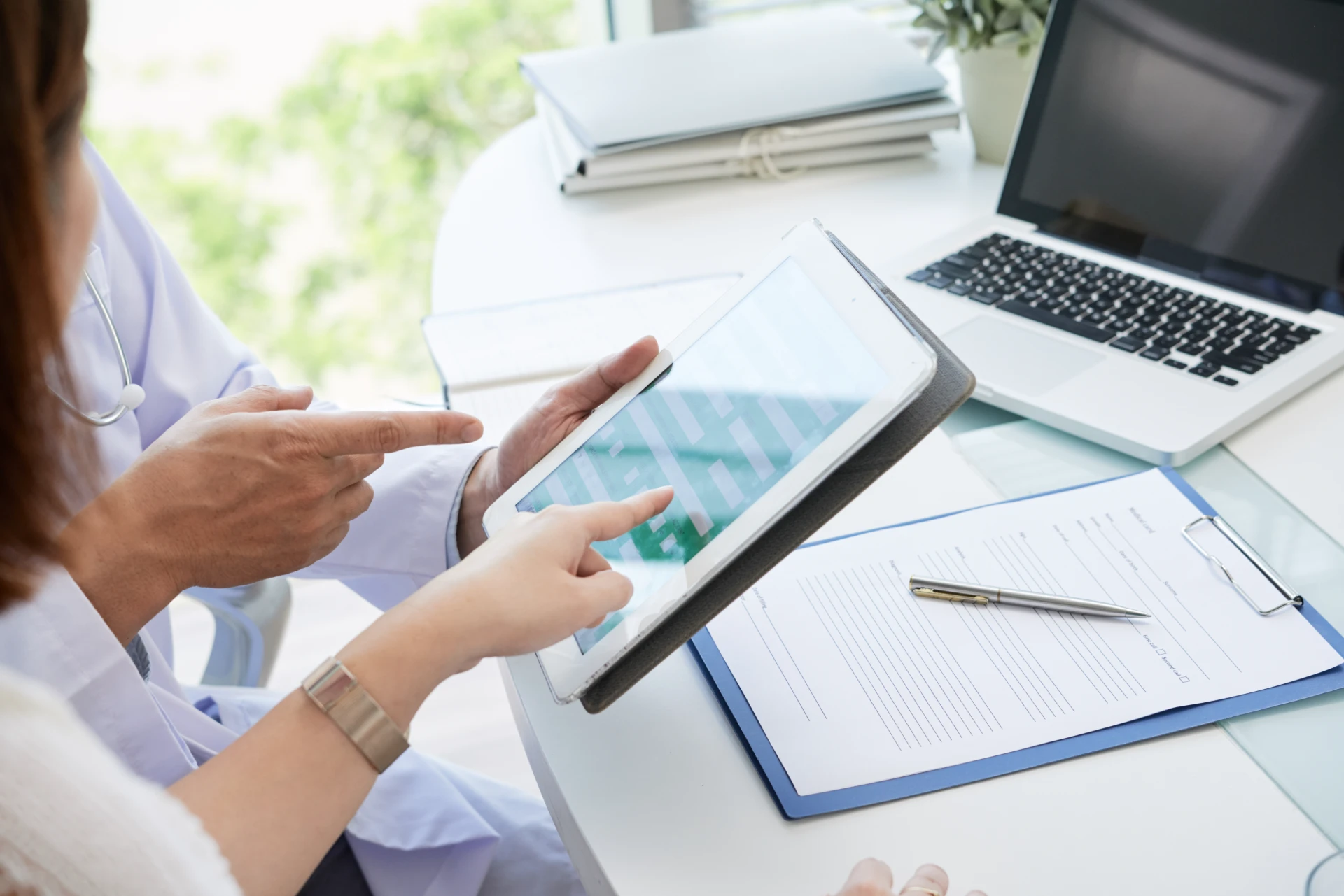 Doctor explaining patient how fill personal data from digital tablet